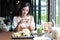 Asian women smiling and happy and enjoyed eating hamburgers at coffee and restaurant on relax time