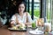 Asian women smiling and happy and enjoyed eating hamburgers at coffee and restaurant on relax time