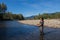 An asian women in waders, enjoying fishing a river in British Columbia, Canada