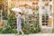 Asian women walking leisure around with nature garden cactus nursery plant shop in summer season with umbrella
