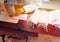 Asian women, white shirt, early work sewn mask, sanitary napkin, patterned fabric, green, pink, wooden table, morning sun, workers