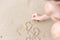 Asian women write sand on the beach