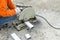 asian worker with machine cutting metal and welded steel to create a roof, local labor construction concept