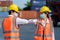 Asian worker new normal greeting by elbows bump wear safety helmet and mask in container depot terminal for prevent coronavirus