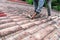 Asian worker replacing roof tiles of old residential building