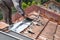 Asian worker replacing roof tiles of old residential building