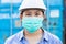 Asian worker wearing disposal face mask for protect dust smoke and corona virus while working in workplace