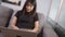 Asian working woman sitting down with laptop computer blurry shot, at home living room sitting on couch, work on her project