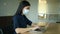 Asian young business woman wears face mask working on laptop