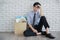 Asian young businessman fired from job sitting sad with his stuff box