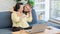 Asian young cheerful pretty female daughter standing behind old chubby senior retirement pensioner mother sitting on sofa in