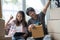 Asian young couple make high five hands after finish packing cardboard box prepare for relocation apartment