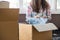 Asian young couple unpack cardboard box after moving in new house