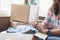 Asian young couple unpack cardboard box after moving in new house