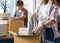 Asian young couple unpack cardboard box after moving in new house