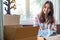 Asian young couple unpack cardboard box after moving in new house