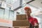 Asian young delivery service man in red uniform sending parcel post box to customer at home