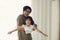 Asian young Father holding little daughter in his arm and girl spread arms like wings