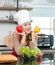 Asian young female chef wears white tall cook hat and apron smiling posing holding red yellow sweet peppers ready to cooking food