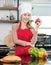Asian young female chef wears white tall cook hat and apron smiling posing holding red yellow sweet peppers ready to cooking food