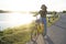 Asian young girl sitting on yellow bicycle on the road nearly river