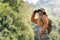 Asian young girl using binoculars in the forest. Explorers and adventurers use binoculars