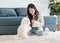Asian young happy cheerful female owner sitting smiling on fluffy carpet floor playing with best friends companion dogs white