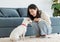 Asian young happy cheerful female owner sitting smiling on fluffy carpet floor playing with best friends companion dogs white