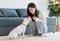 Asian young happy cheerful female owner sitting smiling on fluffy carpet floor playing with best friends companion dogs white