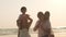 Asian young happy family enjoy vacation on beach in evening. Dad, mom and kid set camera for take photo while relax together near