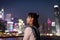 Asian young lady, blurred Colorful magnificent Night city view of Central, Hong Kong in background