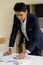 Asian young man as a male investor sits in the study room from the graph of the investment analysis chart. A businessman who is le