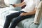 Asian young man pressing TV remote button on sofa at home