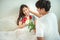 Asian young man surprise girl with roses on bed,husband encourage expected mom wife for pregnancy test,valentine day concept