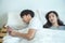 Asian young man use smart mobile phone chatting secrecy on bed while his girlfriend sleeping.Cheating boyfriend Secretly use