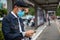 Asian Young man using smart phone in the city and wearing face mask for protection air pollution, particulates and for protection