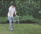 Asian young man wearing aircast boot walking in the garden with orthopedic walker