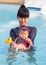 Asian young mother and cute eight month baby enjoy swimming pool