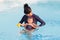 Asian young mother and cute eight month baby enjoy swimming pool