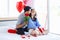 Asian young romantic lover couple male boyfriend holding red roses bouquet closed girlfriend eyes sitting surprised on bed