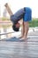 The Asian young strong muscular man doing yoga exercise by the lake in the park in the evening sunset time