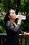 Asian young woman in black and yellow sportswear Thirsty and and drinking water in bottle after exercise and running with natural