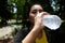 Asian young woman in black and yellow sportwear Thirsty and resting and drinking water in bottle after exercise and running.