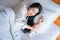 Asian young woman enjoys fresh soft bedding linen and mattress in bedroom, Teenage girl resting, good night sleep concept