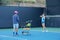 Asian young woman with her trainer practicing outdoor tennis.