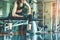 Asian young woman playing dumbbell workout exercise in fitness gym. Relax and Health care concept. Sports and weight training