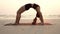 Asian young woman practice Yoga bridge Pose on the sand and beach with sunset