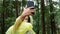 Asian young woman selfie with smartphone at pine forest in raining day.