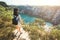 Asian young woman standing lonely and looking something in rocks mountain with lake and tree