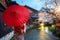 Asian young woman traveller wearing japanese traditional kimono with red umbrella sightseeing at famous destination cherry blossom